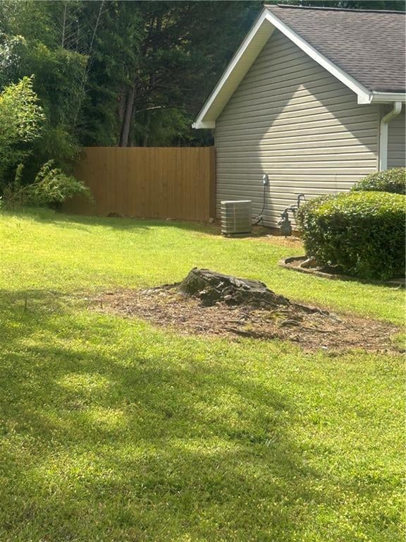 View of yard with fence and cooling unit