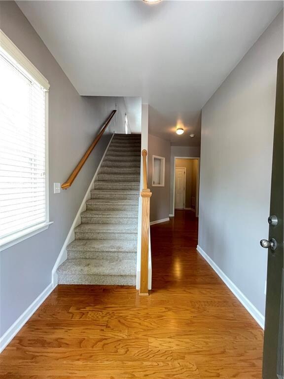 Stairs with baseboards, wood finished floors, and 
