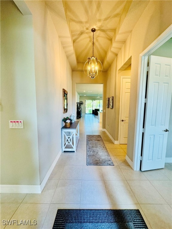 Corridor featuring baseboards, a notable chandelie