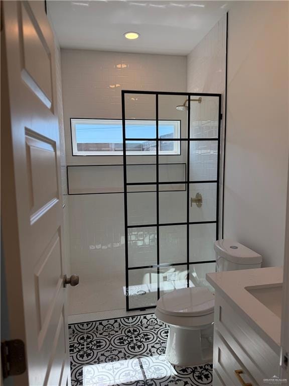Bathroom with walk in shower, vanity, and tile patterned flooring
