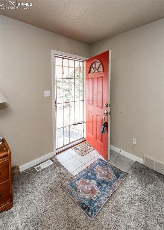 Foyer entrance featuring baseboards, carpet, and a