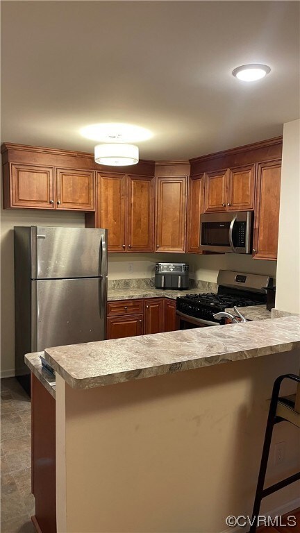 Kitchen with stainless steel appliances, dark tile