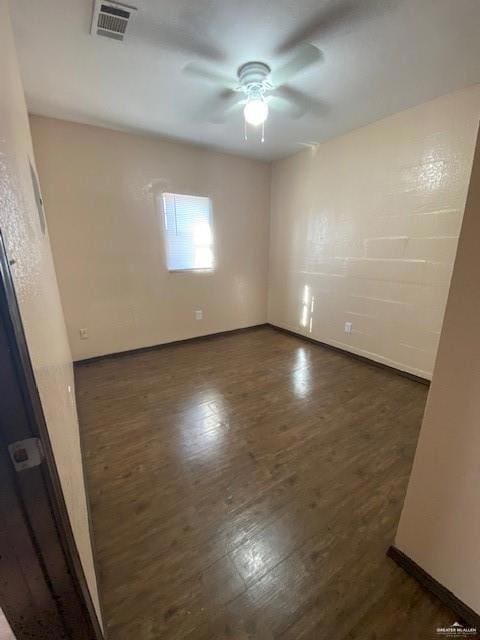 Unfurnished room with ceiling fan and dark hardwood / wood-style flooring