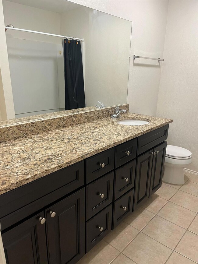 Full bath featuring toilet, tile patterned floorin