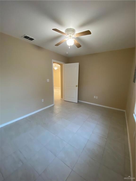 Spare room with baseboards, ceiling fan, and visible vents