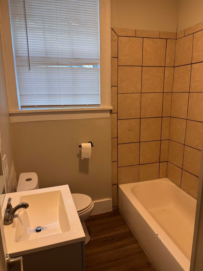Bathroom with wood finished floors, vanity, and tub / shower combination