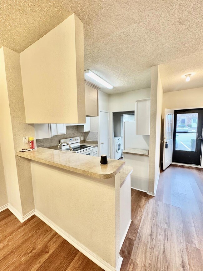 Kitchen with white electric range, wood finished f