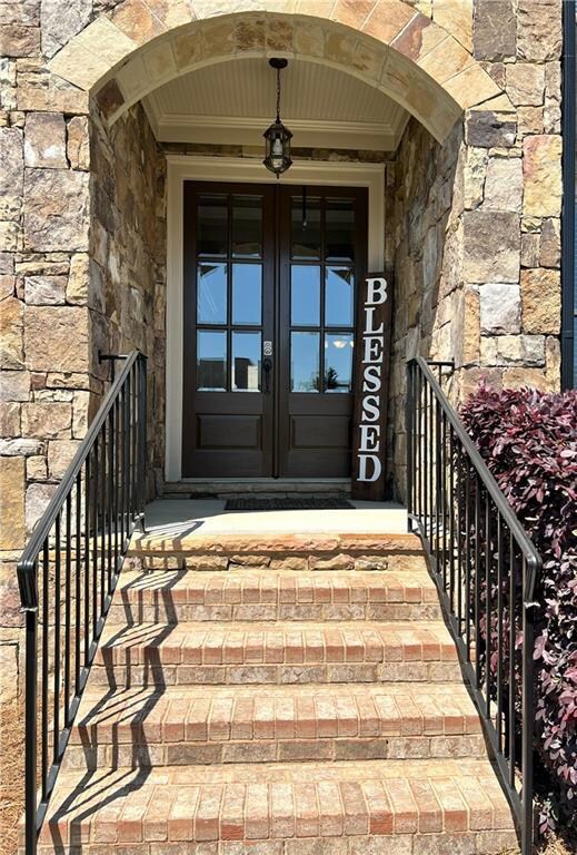 Doorway to property with french doors and stone si