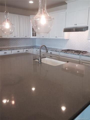 Pendants over island with farmhouse sink