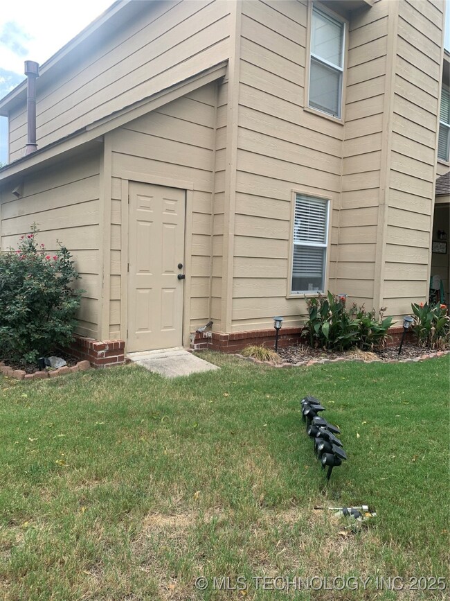View of exterior entry with a yard