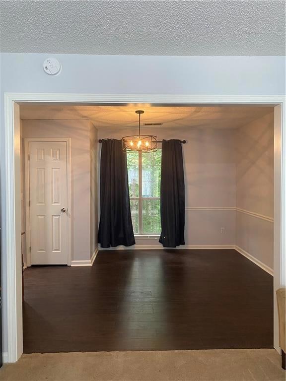 Spare room with a textured ceiling, baseboards, an