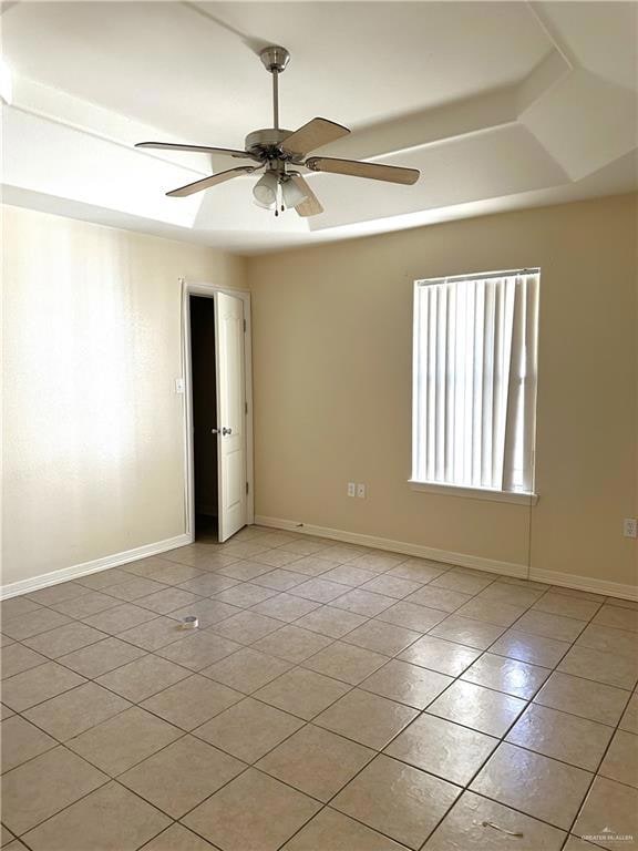 Empty room with light tile patterned flooring and a ceiling fan