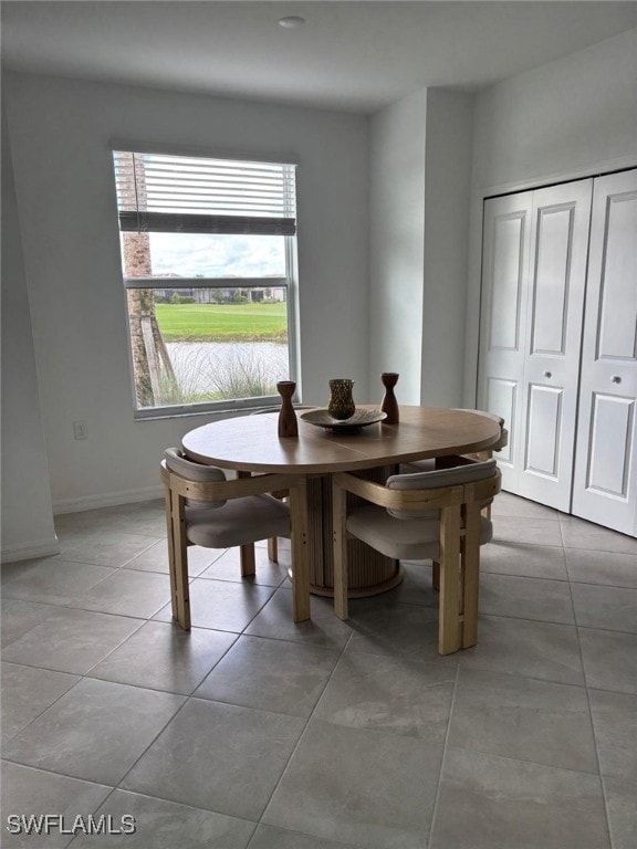 Dining area featuring light tile patterned floors and baseboards