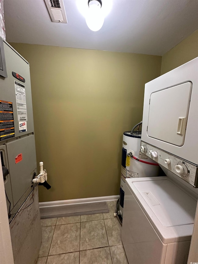 Laundry area with stacked washer and clothes dryer