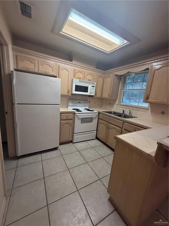 Kitchen with electric stove, fridge, a sink, light tile patterned floors, and decorative backsplash