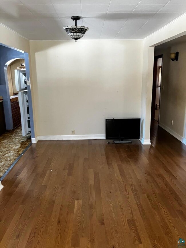 Unfurnished dining area featuring baseboards, wood