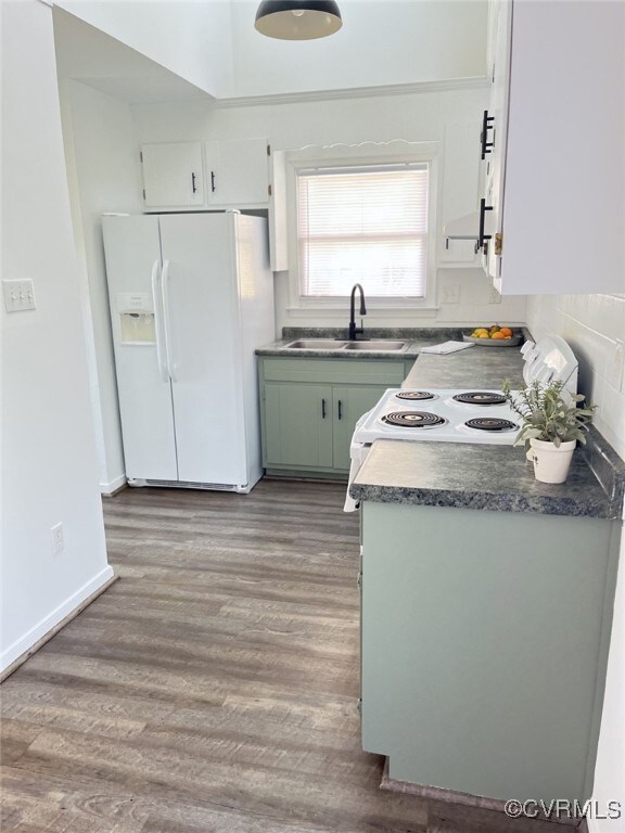 Kitchen with white cabinetry, white appliances, si