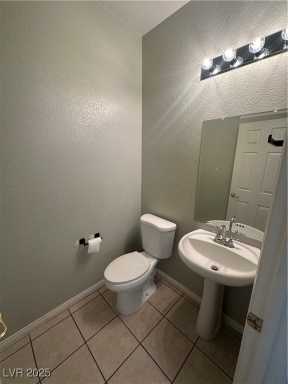 Half bath with tile patterned flooring, toilet, ba