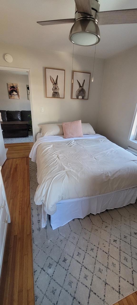 Bedroom featuring wood finished floors and a ceiling fan