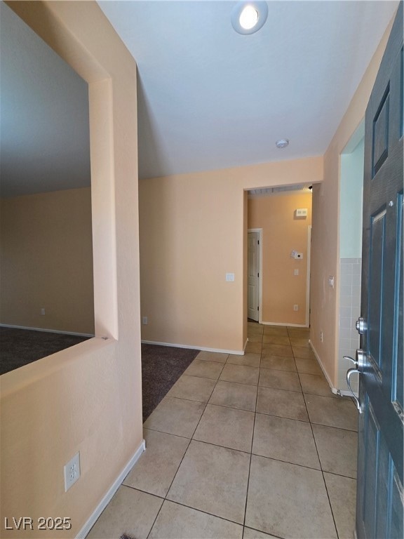 Corridor with light tile patterned floors and base