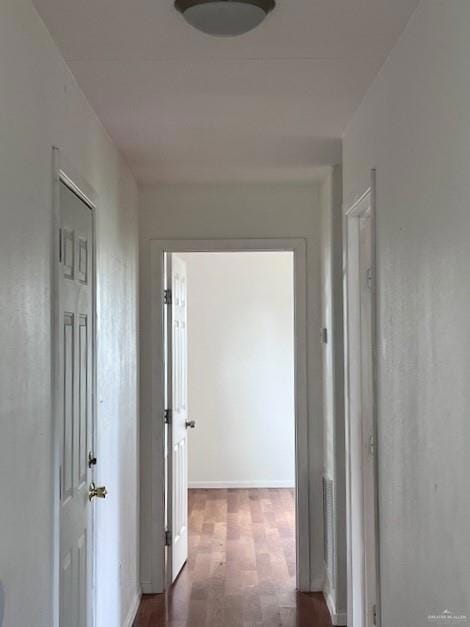 Corridor with wood finished floors and baseboards