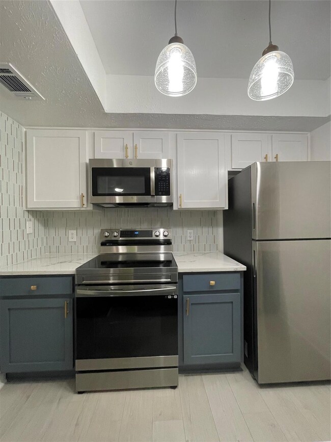Kitchen with fridge, tasteful backsplash, range, a