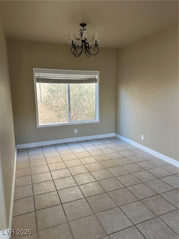 Spare room with baseboards, light tile patterned f