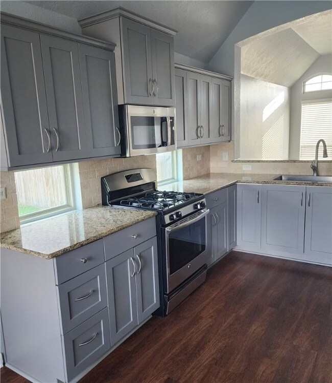 Kitchen with stainless steel appliances, gray cabi