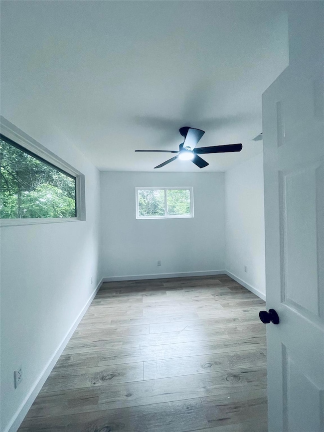 Unfurnished bedroom with light wood-style floors and a ceiling fan