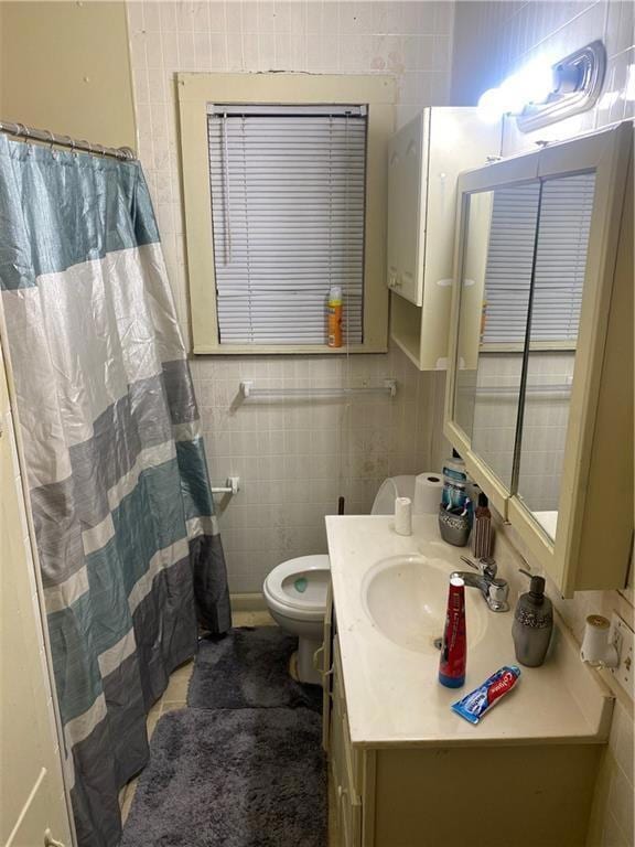 Bathroom featuring vanity, tile walls, and toilet