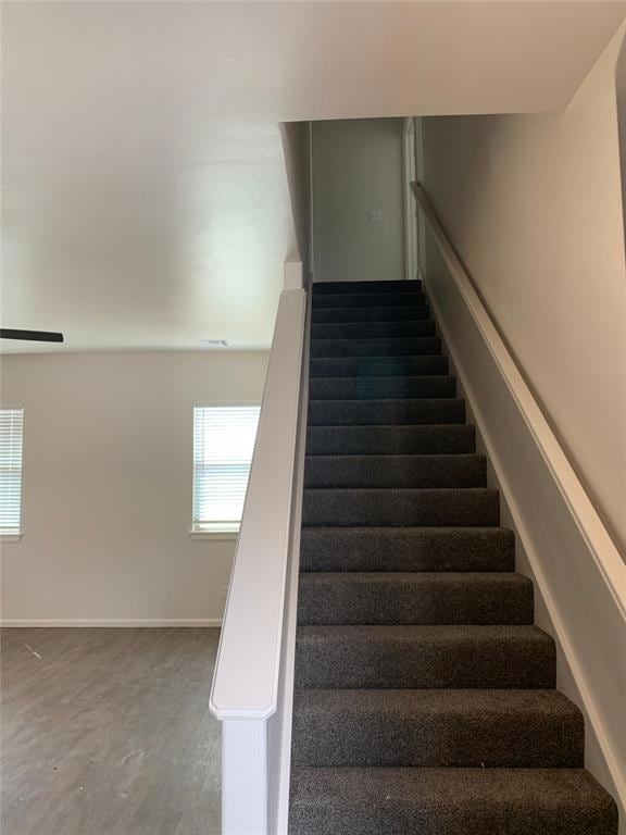 Staircase featuring wood finished floors and baseb