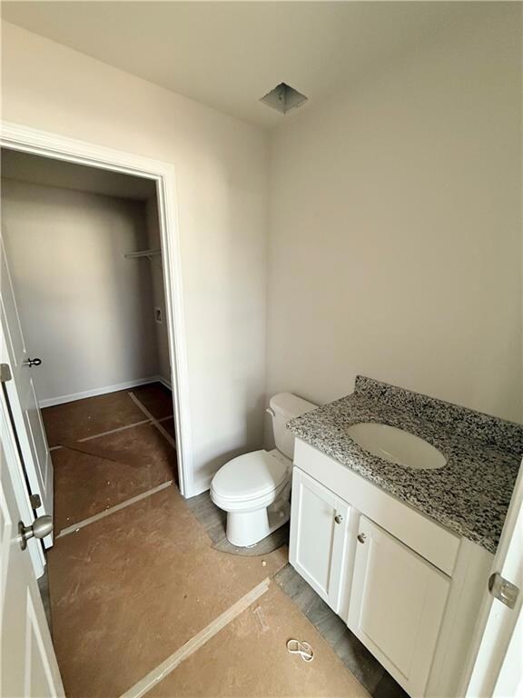 Half bathroom featuring toilet and vanity