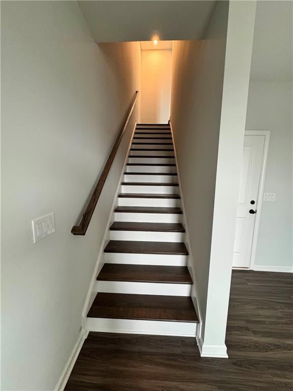 Staircase featuring wood finished floors and baseboards