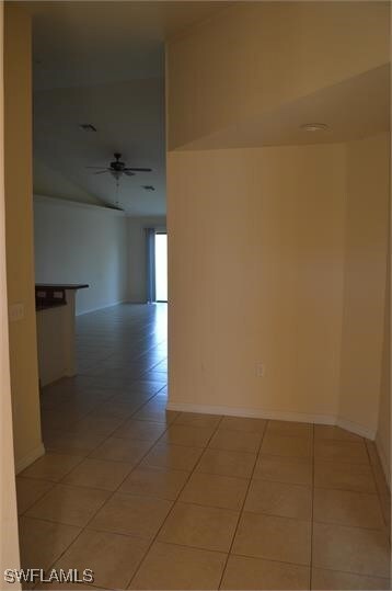 Tiled spare room featuring ceiling fan