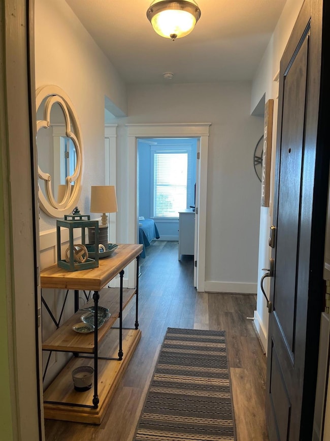 Hallway with dark hardwood / wood-style floors