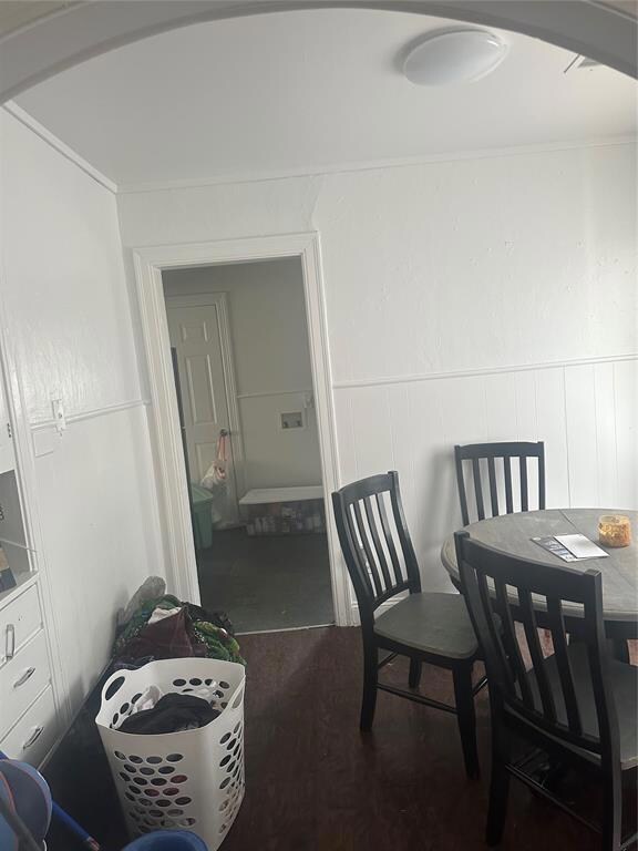 Dining room featuring wainscoting and a decorative wall