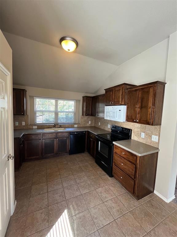 Kitchen featuring black appliances, lofted ceiling