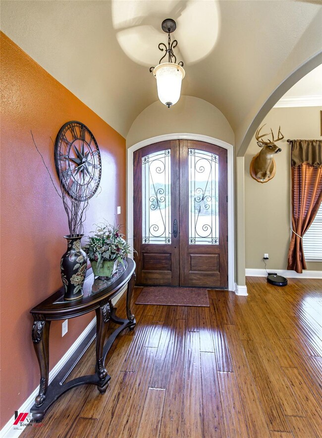 Entryway with dark hardwood / wood-style floors, french doors, and lofted ceiling