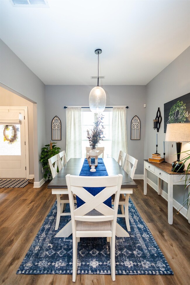 Dining space with dark hardwood / wood-style floor