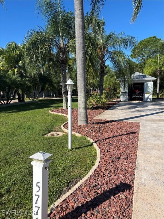 View of grassy yard featuring concrete driveway