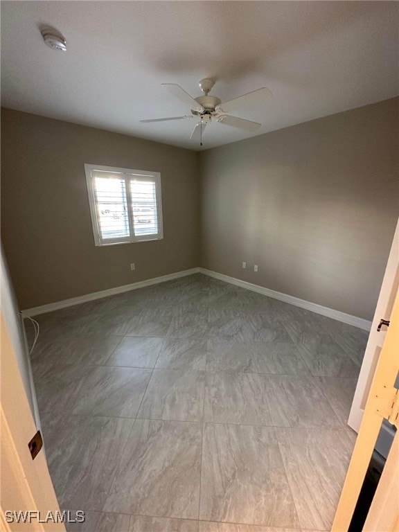 Empty room featuring a smoke detector and a ceiling fan