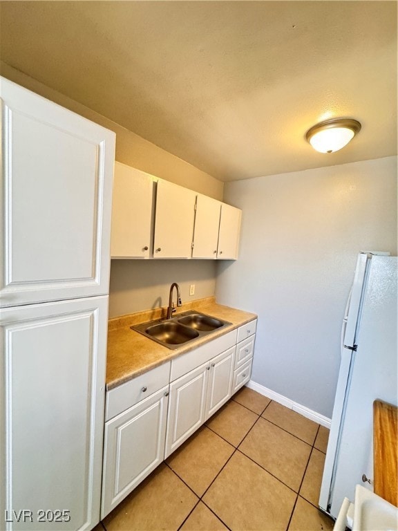 Kitchen featuring white cabinets, a sink, light co