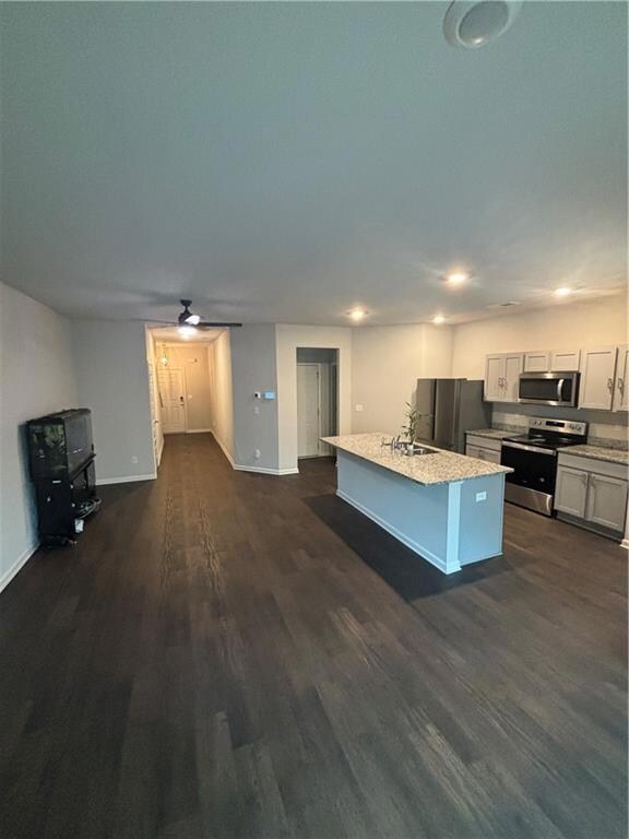 Kitchen with range, fridge, a ceiling fan, dark wo