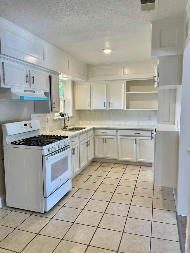 Kitchen with white range with gas stovetop, tastef