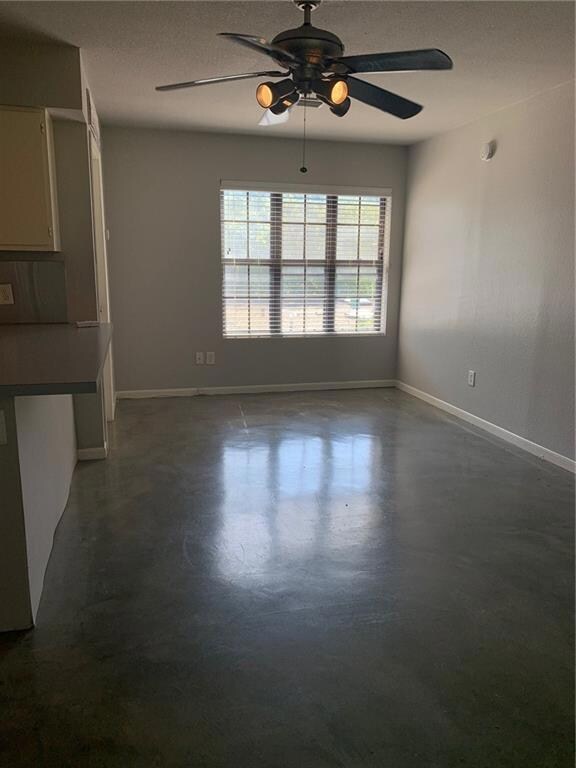 Unfurnished living room with ceiling fan and fini