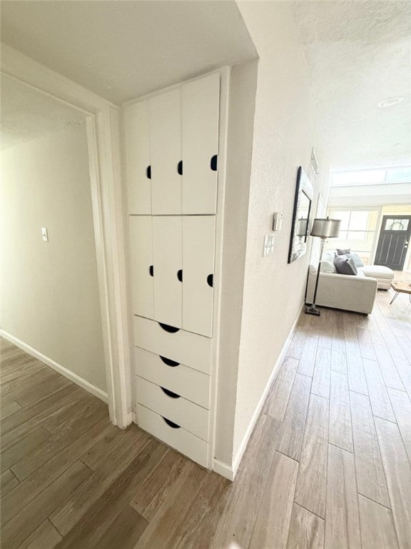 Hallway with wood finished floors and baseboards