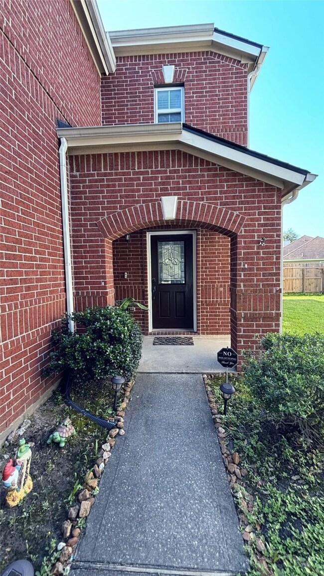 Welcoming brick exterior with a charming arched en