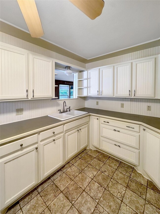 Kitchen featuring sink, ornamental molding, ceilin