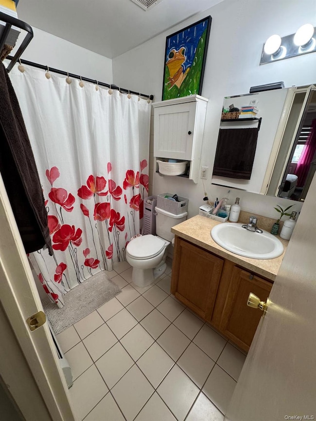 Bathroom featuring light tile patterned flooring, vanity, and shower / bathtub combination with curtain