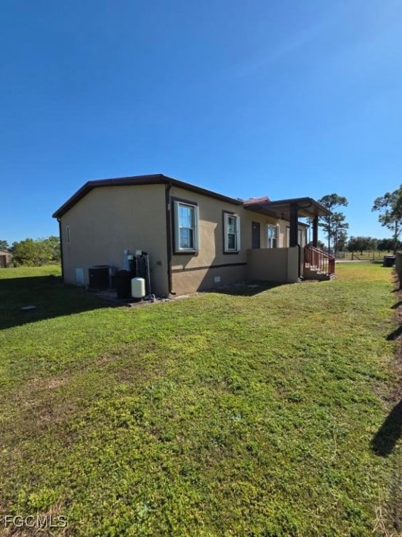 Back of property featuring stucco siding and a lawn